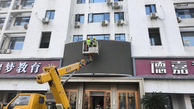 大楼上擅自设置LED电子广告屏武昌城管依法拆除还优美公共空间(图1)